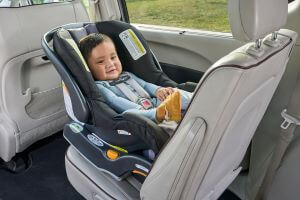 An infant is pictured here sitting in a rear-facing position anxiously awaiting a ride.